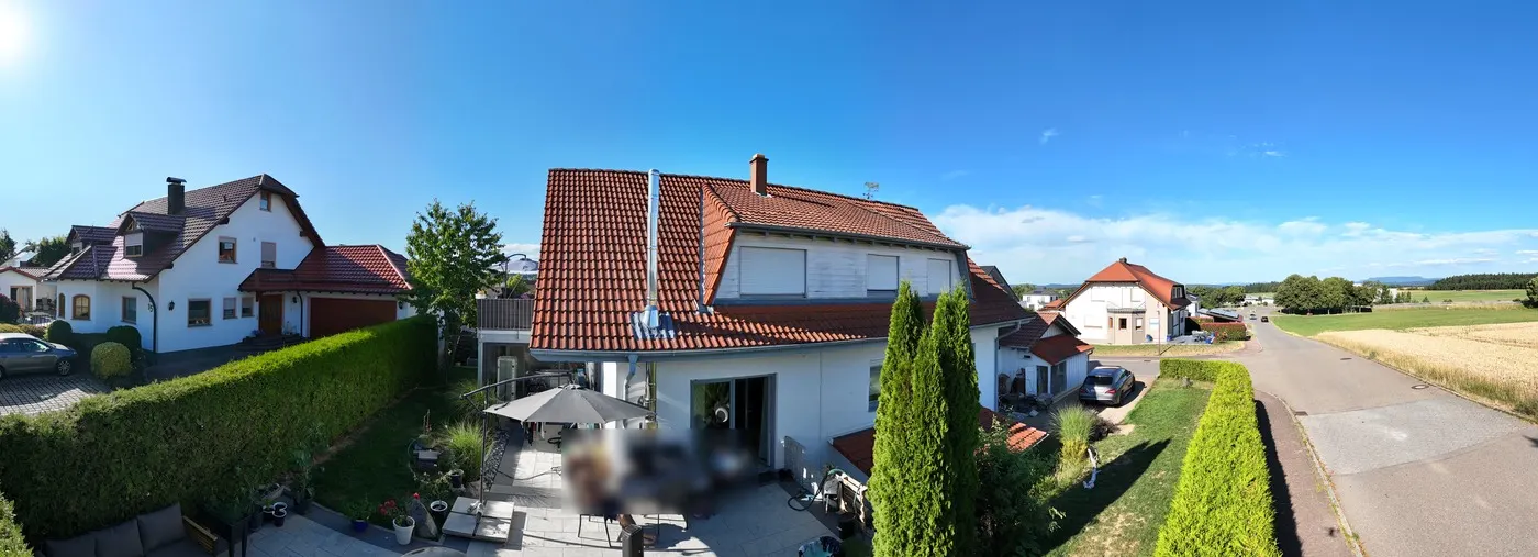360-Grad-Panorama eines Wohnhauses mit Garten und Straße, Sitzbereich auf der Terrasse unkenntlich gemacht