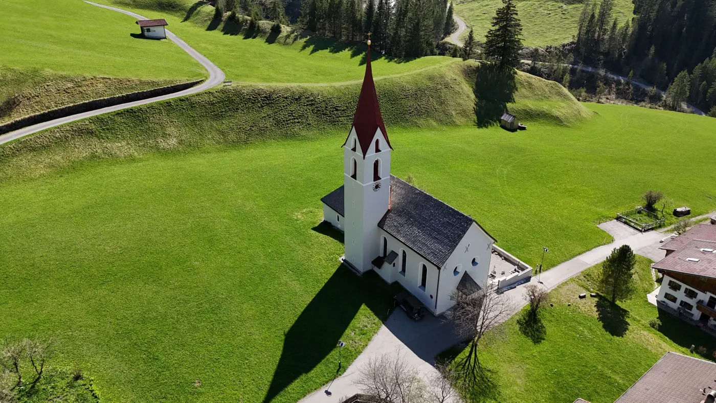 Luftaufnahme einer kleinen Kirche inmitten einer grünen Wiese