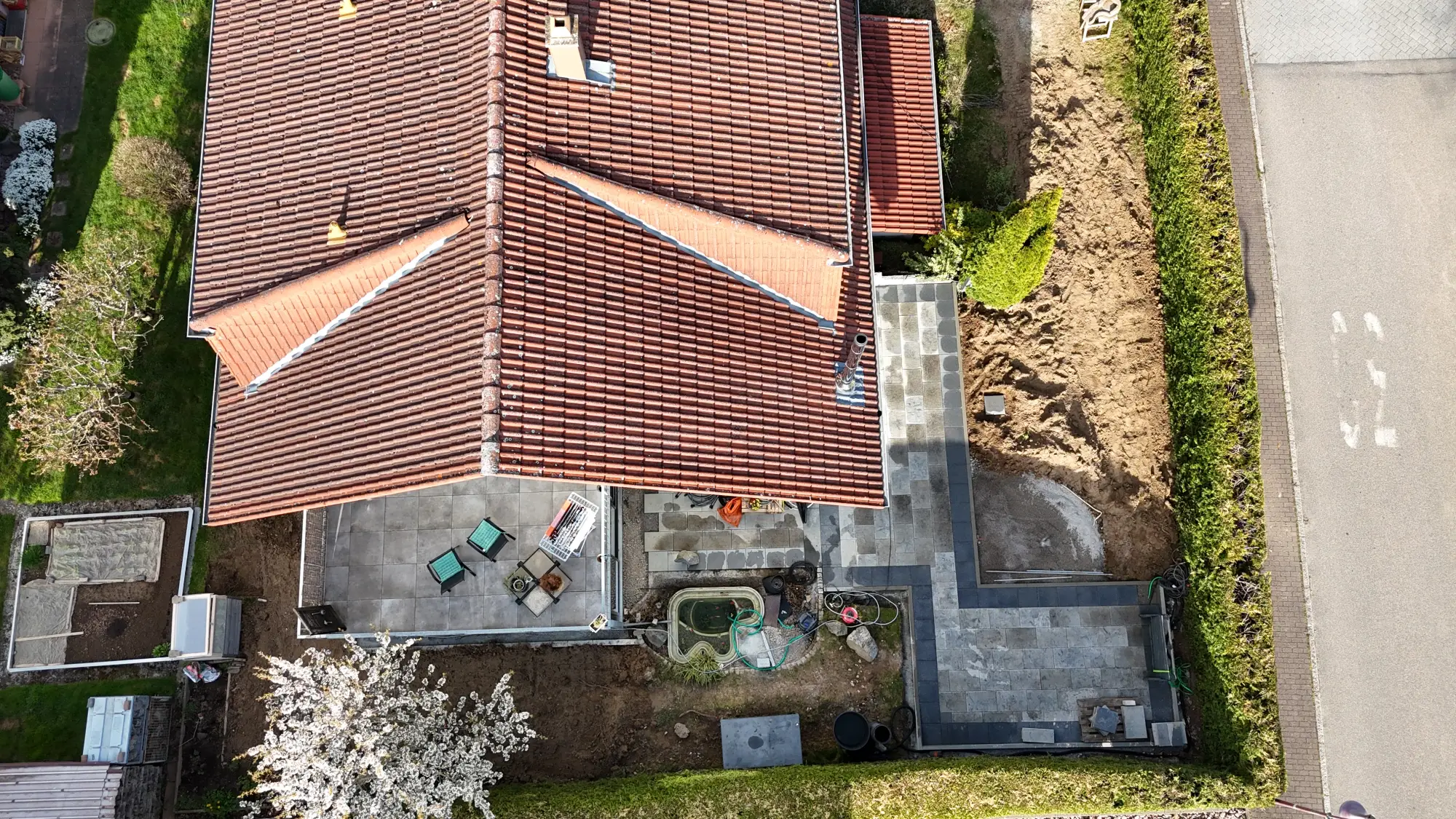 Luftaufnahme eines Einfamilienhauses mit Garten, Carport und Zufahrt