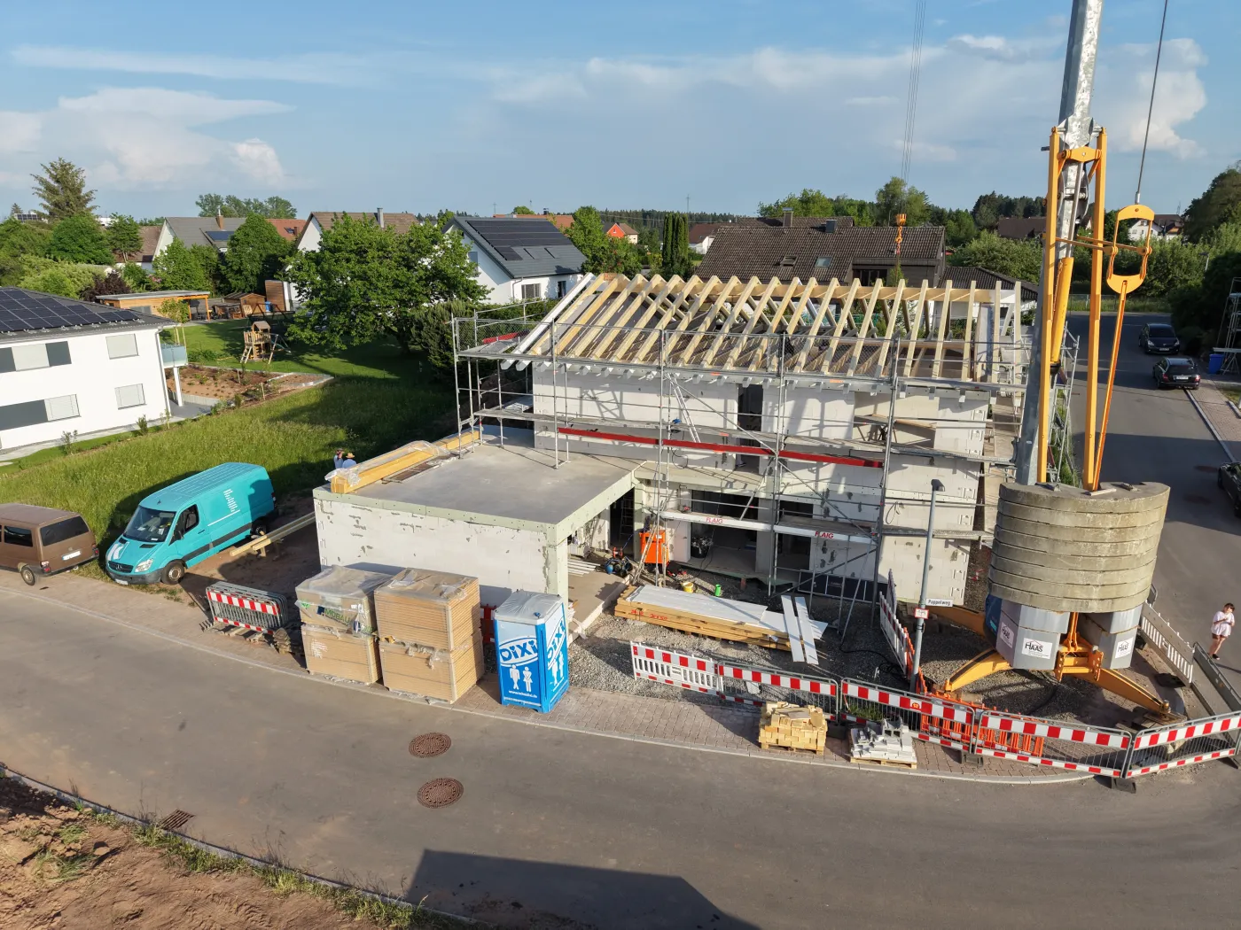 Luftaufnahme eines Dachstuhls im Rohbau mit Baukran