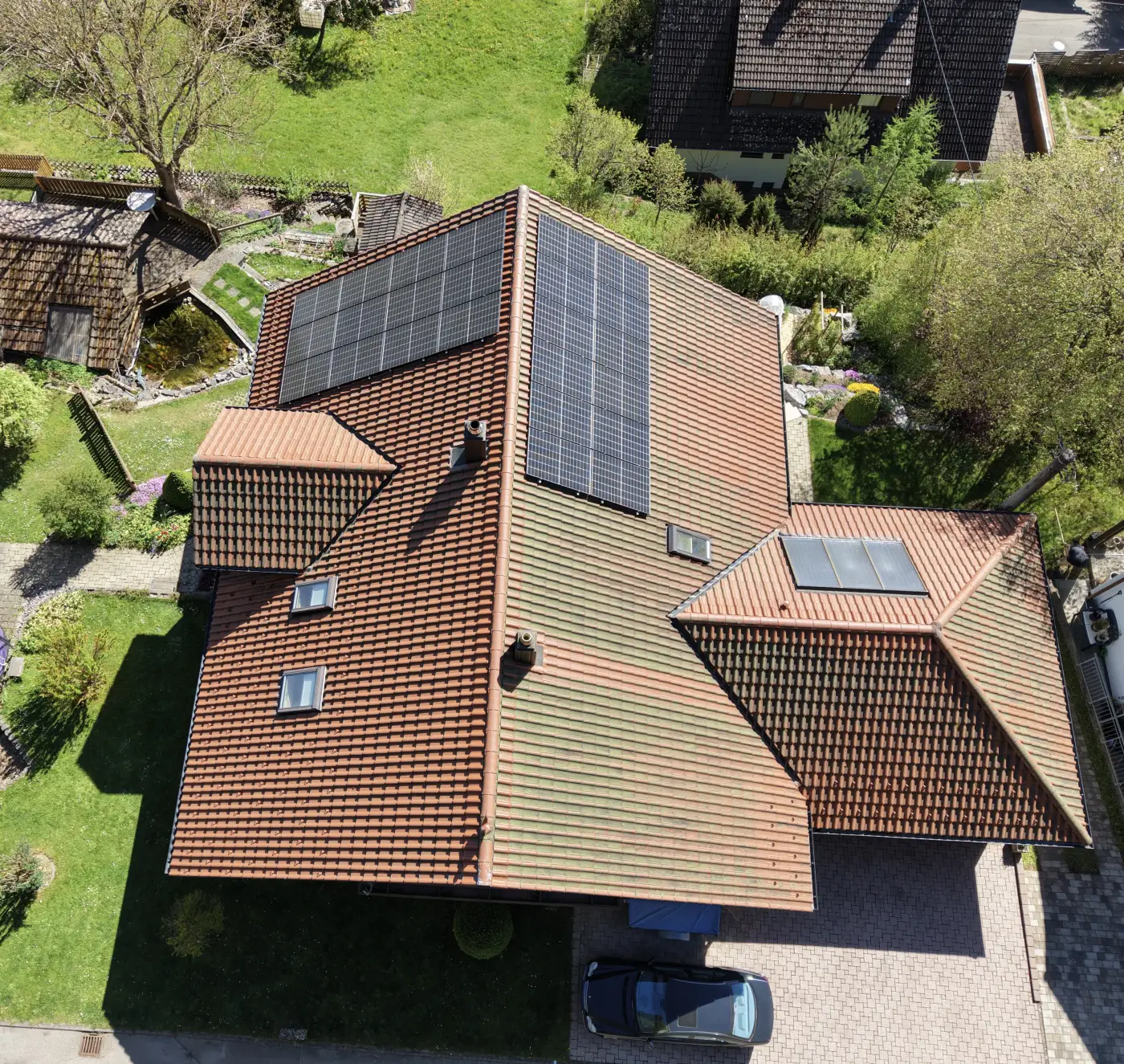 Luftaufnahme eines Wohnhausdachs mit Photovoltaikanlage von schräg oben